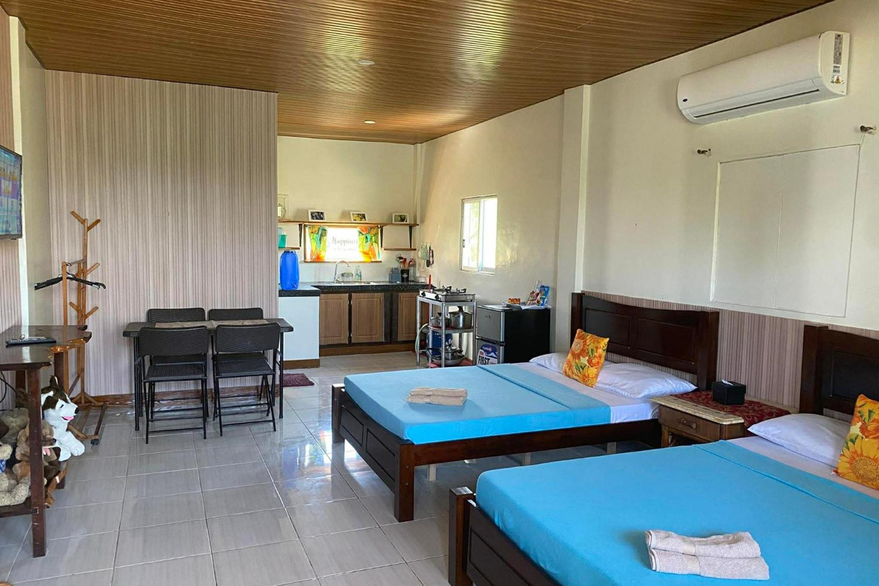 Standard Room at Happy's Homestay — twin beds, kitchenette, and tropical views